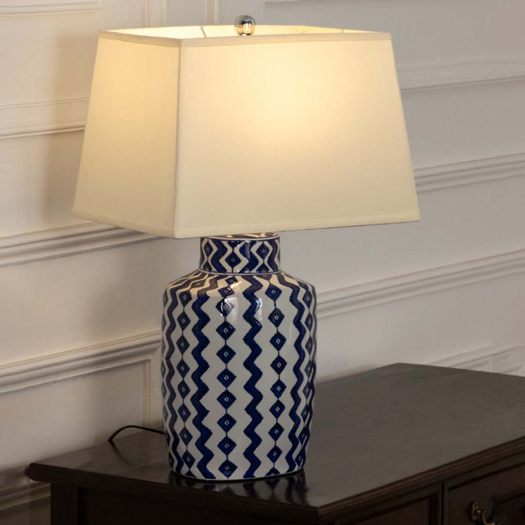 Blue and white ceramic table lamp with fabric shade creating timeless traditional decor and warm ambient lighting.