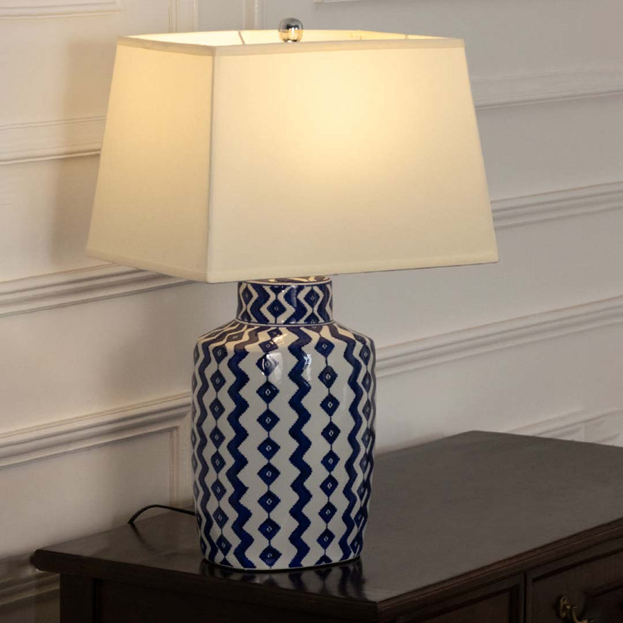 Blue and white ceramic table lamp with fabric shade creating timeless traditional decor and warm ambient lighting.