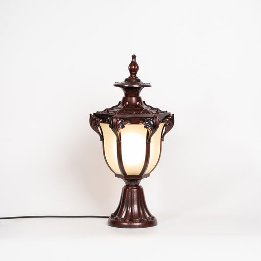 Antique brown outdoor gate light with glowing glass shade for luxury exterior decor styling use.