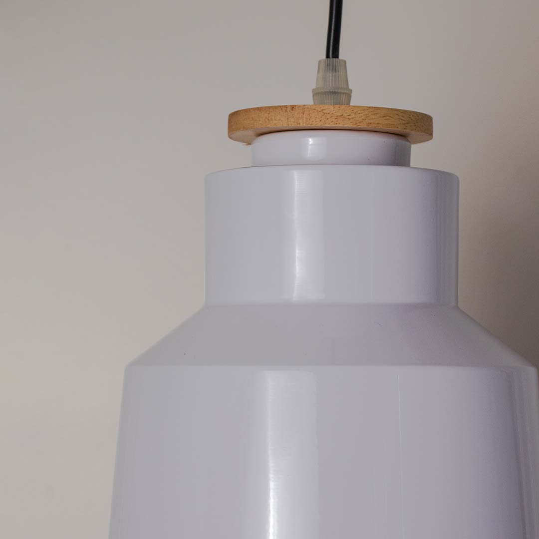 Closeup of tall conical pendant light with white metal shade and wooden detail highlighting modern minimal design.