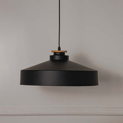 Black metal pendant light with wide drum shade crafted for modern kitchens and dining spaces.