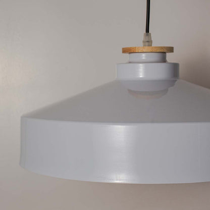 Closeup of white dome pendant lamp with wide metal shade and wooden detail highlighting modern industrial design.