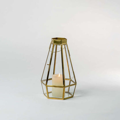 Gold metal geometric candle holder with open frame design for elegant modern tabletop decor styling.