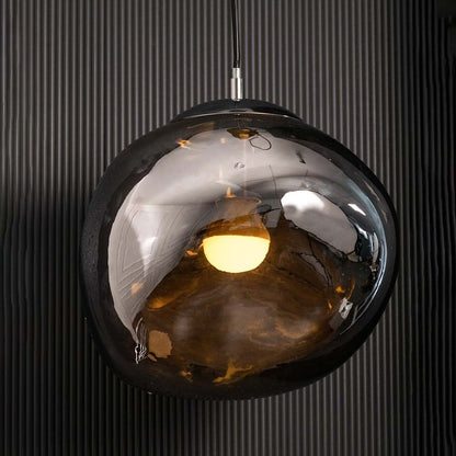 A modern smoked glass pendant light glowing warmly against a dark textured wall creating a rich ambient lighting effect for luxury interior styling.