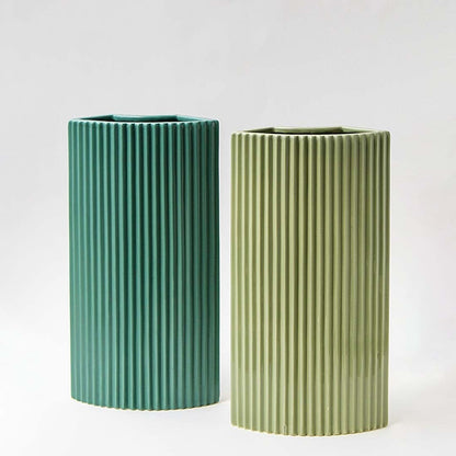 Set of modern teal ceramic vases featuring vertical ribbed patterns styled  for a sophisticated home decor display.