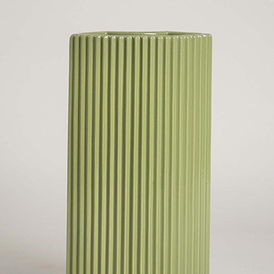 Closeup view of the green decorative vase highlighting its smooth glossy finish and crisp vertical ribbed lines that enhance its modern sculptural look in detail.