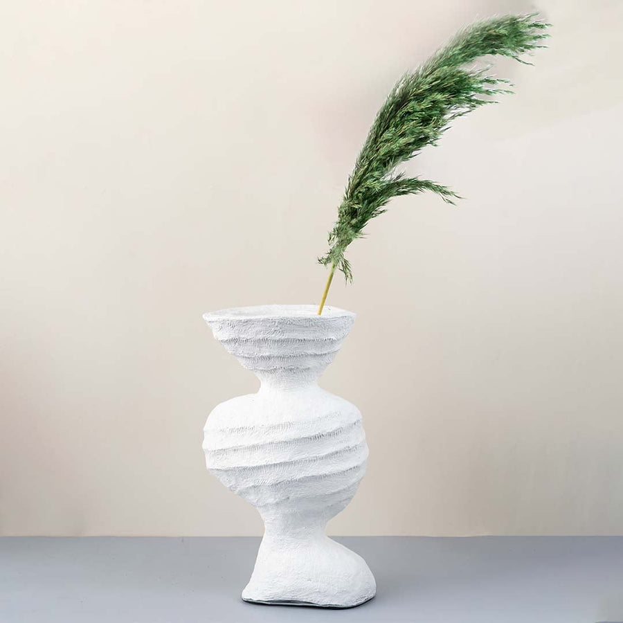 White ceramic sculptural vase with textured surface styled with green pampas stem for modern home decor.