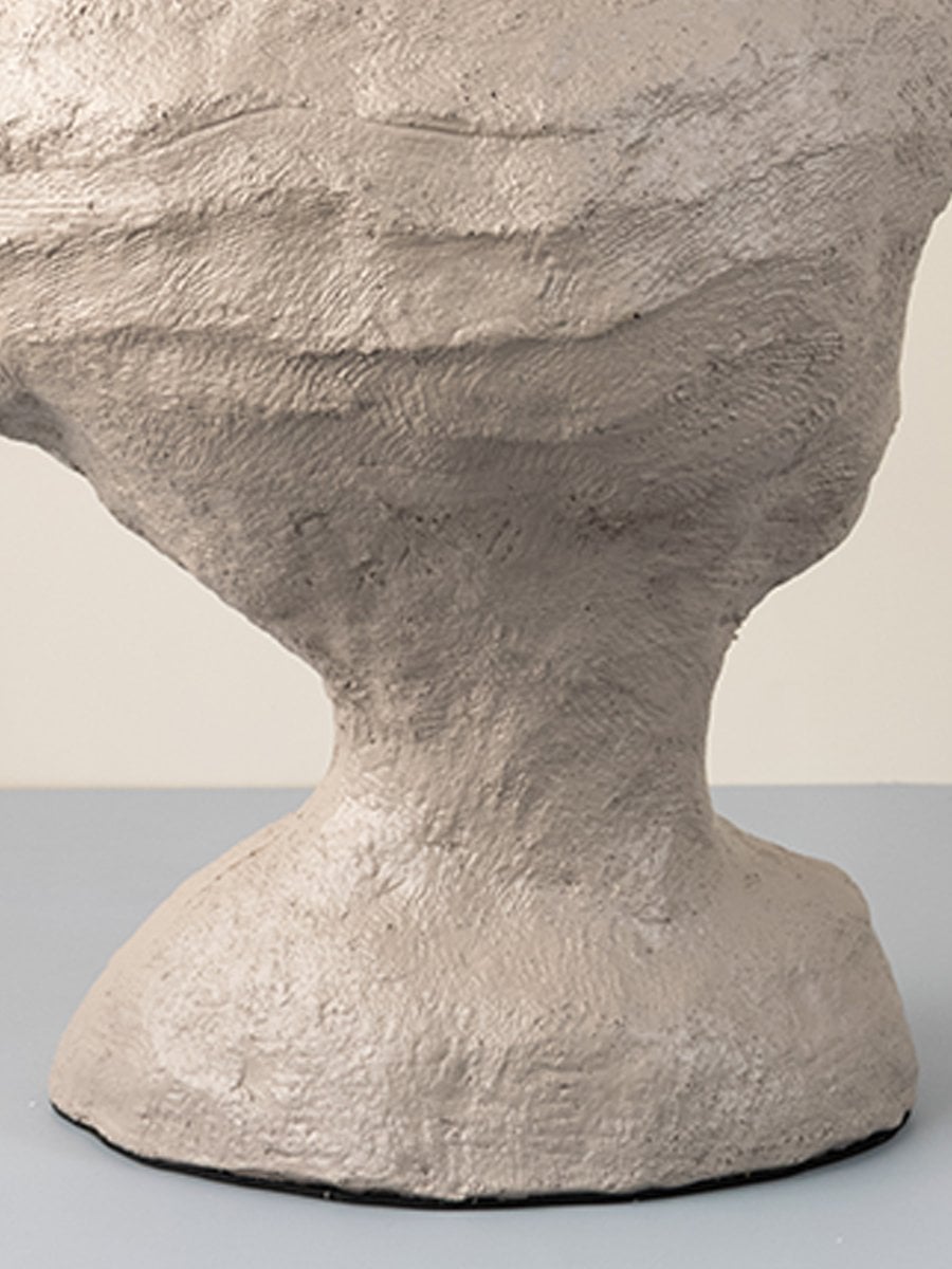 Detailed closeup of sculptural beige ceramic vase highlighting textured finish for modern interior decoration.
