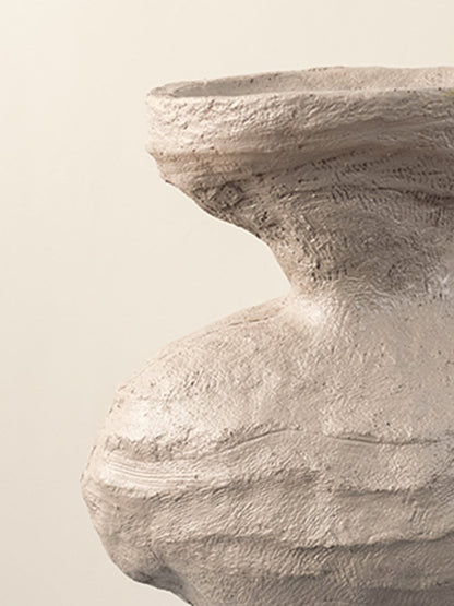 Closeup of beige ceramic vase showing textured sculptural details and artistic organic shape for home styling.