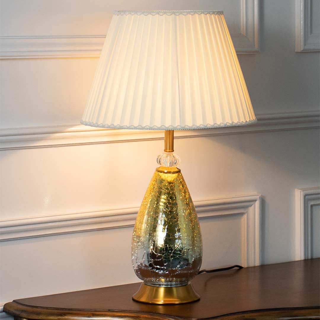 Green textured glass table lamp with pleated fabric shade creating refined luxury lighting for elegant home interiors.