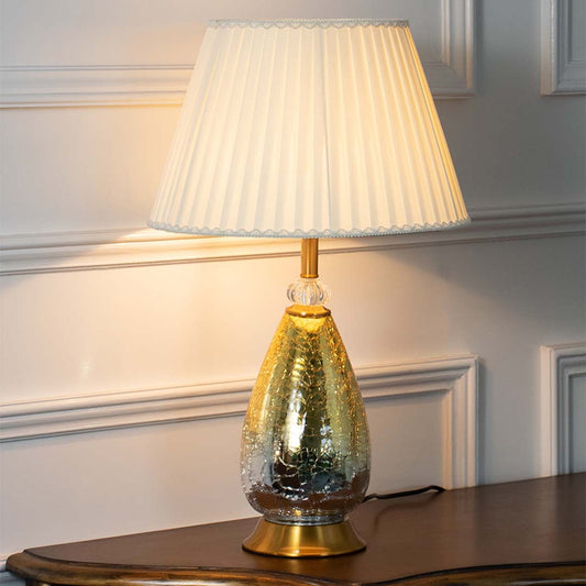 Green textured glass table lamp with pleated fabric shade creating refined luxury lighting for elegant home interiors.