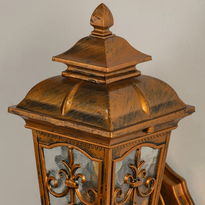 A closeup view of the gold outdoor wall lantern highlighting its textured finish and intricate detailing on the glass and metal frame for an elegant exterior look.