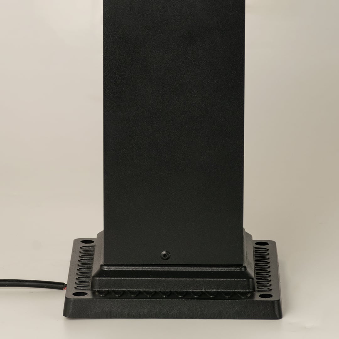 Closeup of black outdoor pillar lamp showing clear framed glass and warm filament bulb detail suitable for elegant garden and pathway lighting.