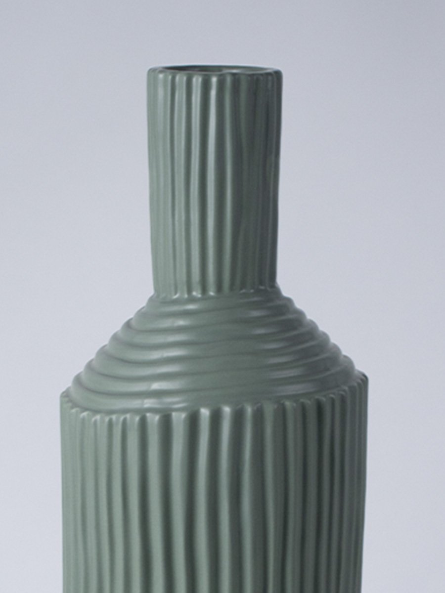 Closeup image of a matte sage green ceramic vase featuring combined vertical and horizontal ribbed patterns on an angled neck.