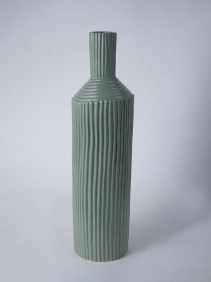 Tall ribbed green ceramic vase shown on a clean white background highlighting its modern sculpted design.