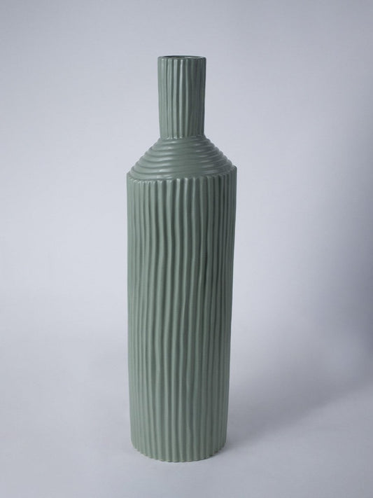 Tall ribbed green ceramic vase shown on a clean white background highlighting its modern sculpted design.