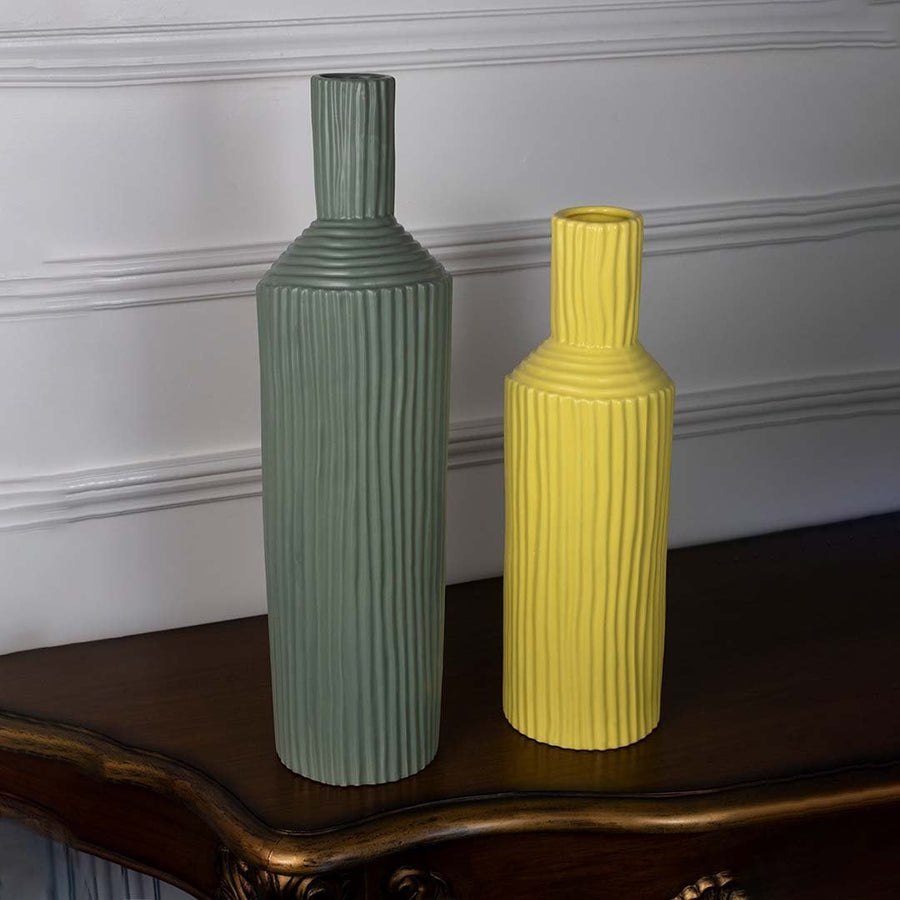 Yellow ribbed ceramic vase styled with matching decor pieces perfect for vibrant modern interiors and artistic home settings.