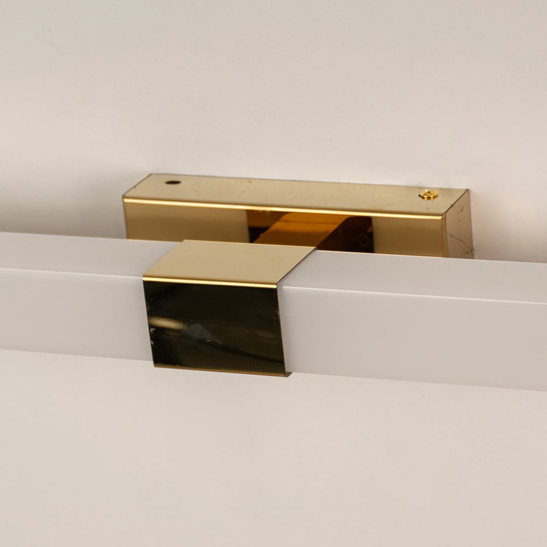 Closeup of white and gold picture light showing sleek bar design for stylish modern wall lighting and elegant home décor accents.