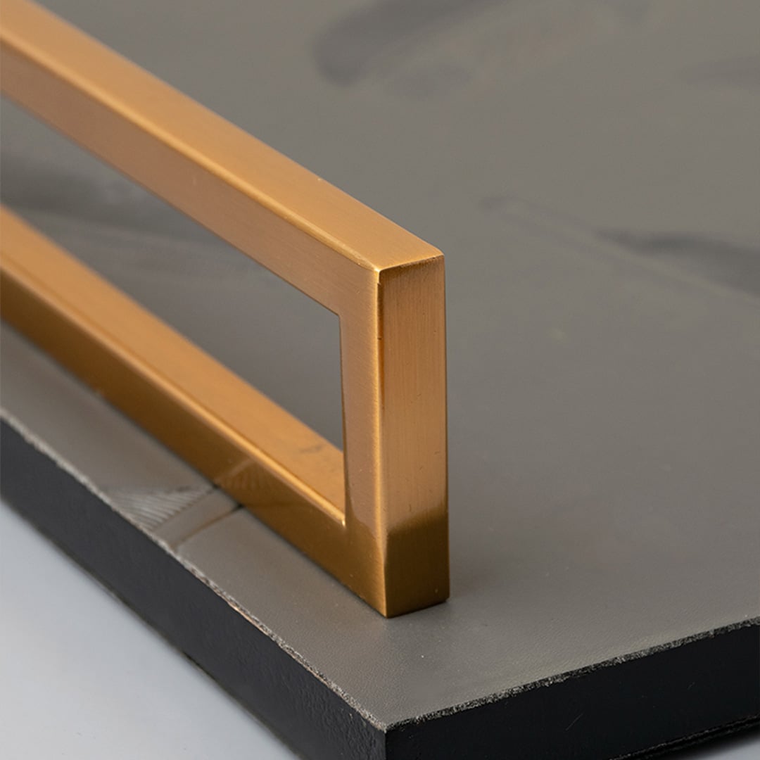 Feather decorative tray detailed closeup showing feather textured grey surface with golden handles for stylish interiors.