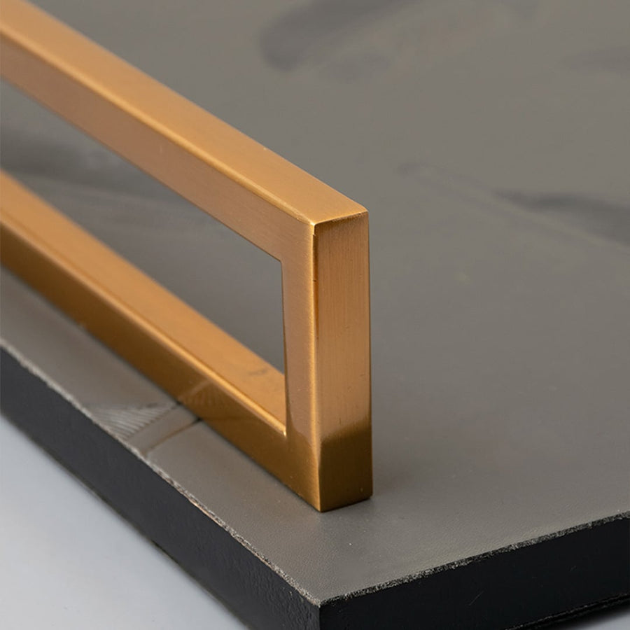 Feather decorative tray detailed closeup showing feather textured grey surface with golden handles for stylish interiors.