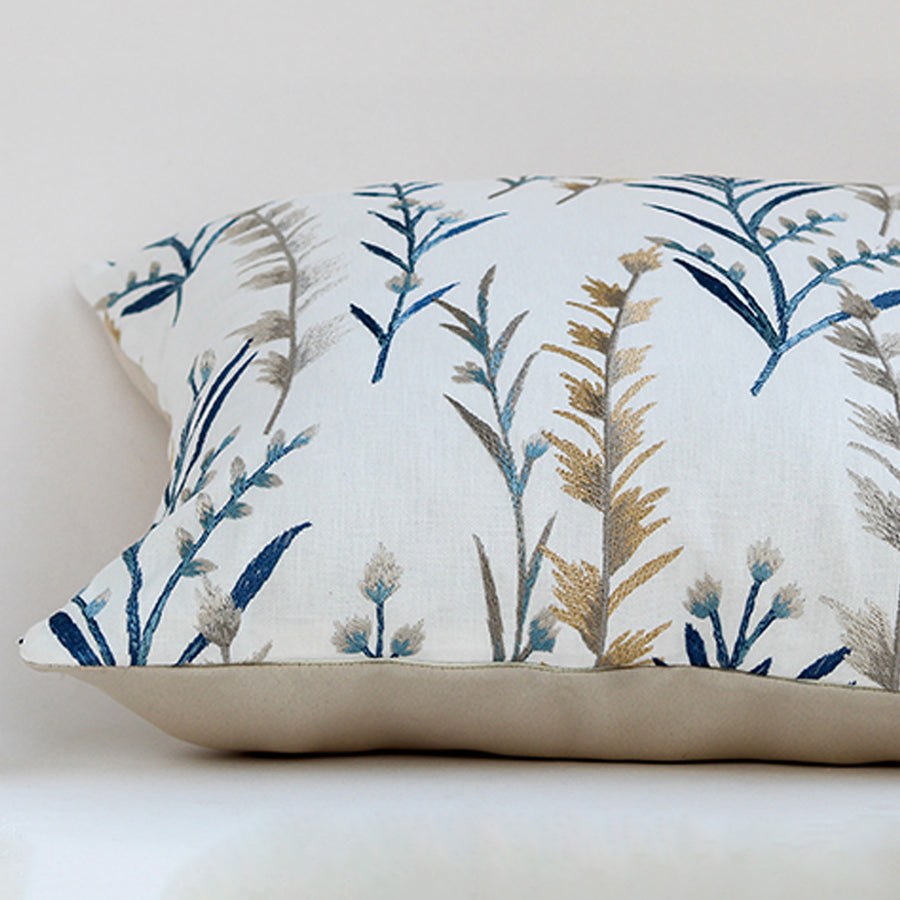 White cotton cushion cover with blue botanical leaf print for sofa bedroom seating and premium home decor styling.