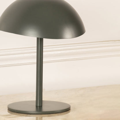 Green metal table lamp with dome shade and sleek stem base showcasing modern minimalist design and craftsmanship.
