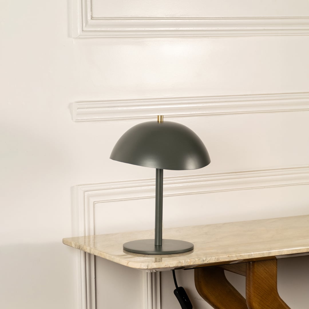 Green metal table lamp with dome shade and sleek stem base for modern desk and console table decor.