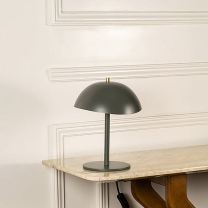 Green metal table lamp with dome shade and sleek stem base for modern desk and console table decor.