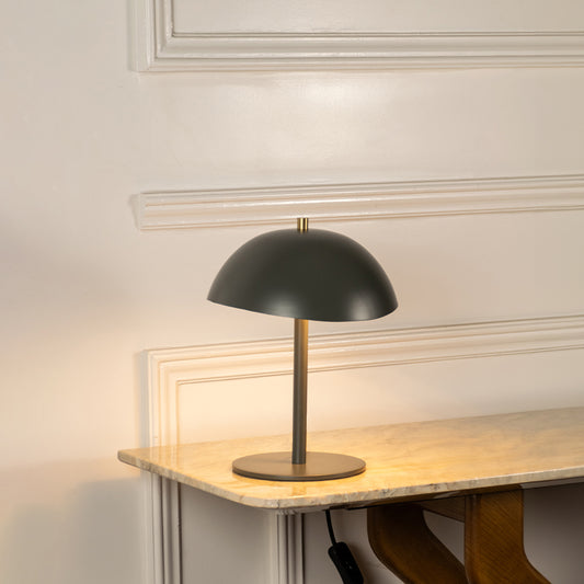 Table lamp with black metal dome shade and minimal base ideal for modern bedroom or living room table decor on clean background.