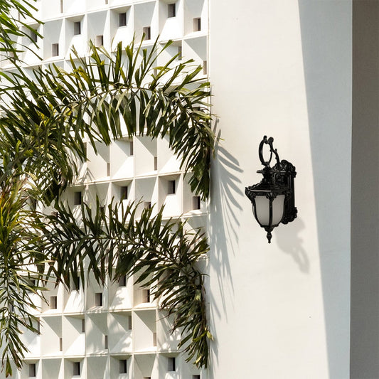 Elegant black metal wall lantern with frosted glass ideal for outdoor home entrances adding classic warm lighting style.