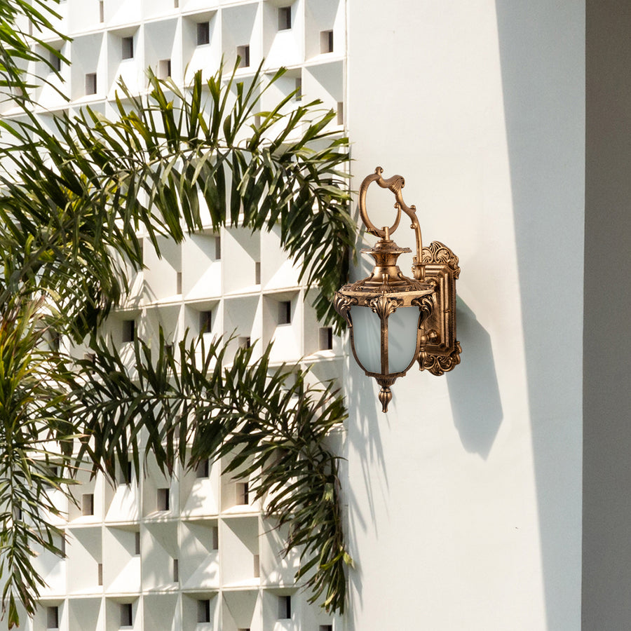 Antique outdoor wall light mounted beside an ornate entrance creates a warm and inviting outdoor ambiance.