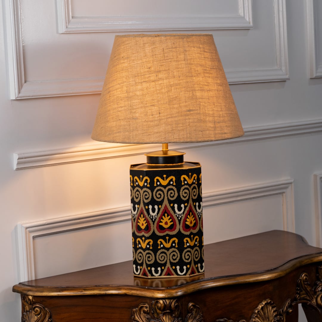 Festoon Damask table lamp illuminated on white background highlighting classic pattern warm glow and timeless interior decor elegance.