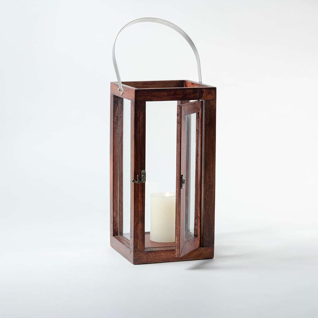 Wooden lantern with clear glass panels and silver metal handle for rustic tabletop decor styling.