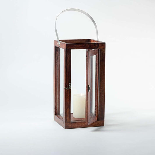 Wooden lantern with clear glass panels and silver metal handle for rustic tabletop decor styling.
