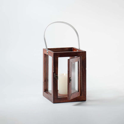 Wooden lantern with clear glass panels and silver metal handle for rustic tabletop decor styling.