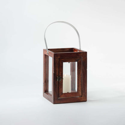 Elegant wooden lantern with glass panels and metal handle featuring lit candle on white background perfect for home styling.