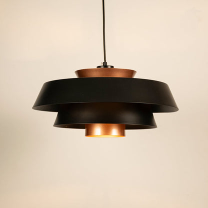 Black and copper metal pendant light glowing softly on white background creating modern industrial ambience for home decor.