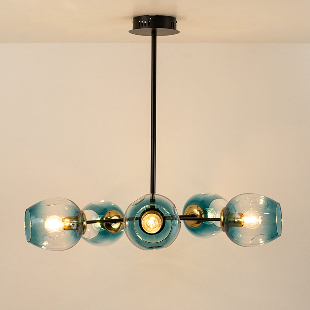 Blue tinted glass chandelier with gold and black metal frame creating elegant modern ceiling lighting for stylish interiors.