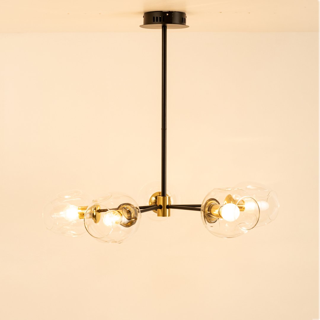 Blue tinted glass chandelier with illuminated glass shades and gold metal accents for contemporary decorative lighting.
