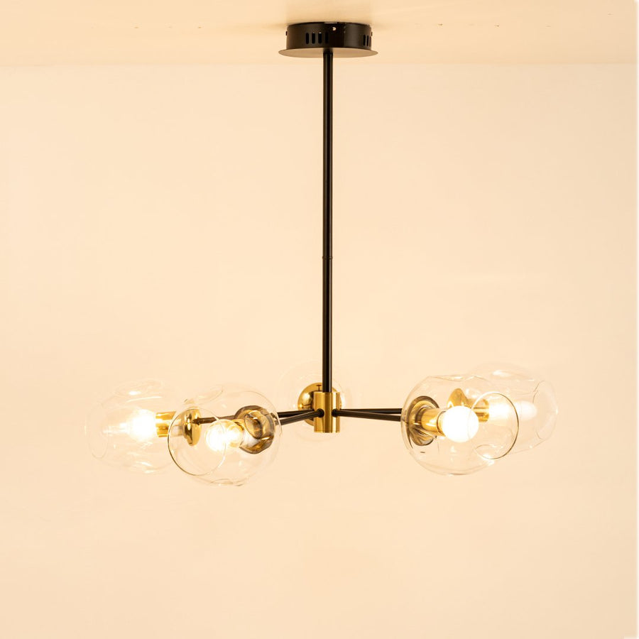 Blue tinted glass chandelier with illuminated glass shades and gold metal accents for contemporary decorative lighting.