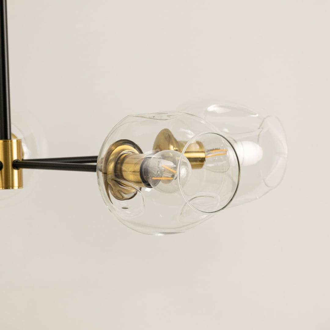 Close view of gold and black clear glass globes chandelier showing artistic glass texture metallic joints and refined handcrafted modern finish.