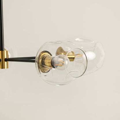 Close view of gold and black clear glass globes chandelier showing artistic glass texture metallic joints and refined handcrafted modern finish.