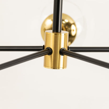 Close-up view of a modern chandelier fixture featuring black metal rods and a gold brass connector for an elegant lighting design.