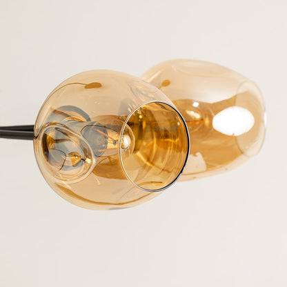 Closeup of amber glass globe light shade showing smooth curved surface warm tint and premium glass craftsmanship detail.