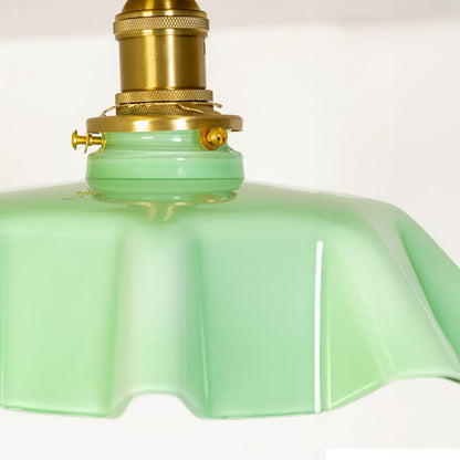 Closeup view of the mint green ruffled ceiling light showing its soft glass texture and gold mount details.