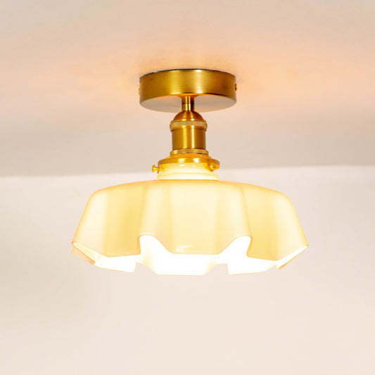 Pink glass ceiling light illuminated on a white background showing warm ambient glow and stylish metal mount.
