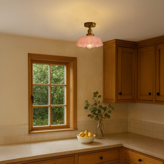Pink glass ceiling light with gold metal mount styled in a modern room setting for soft ambient home lighting.