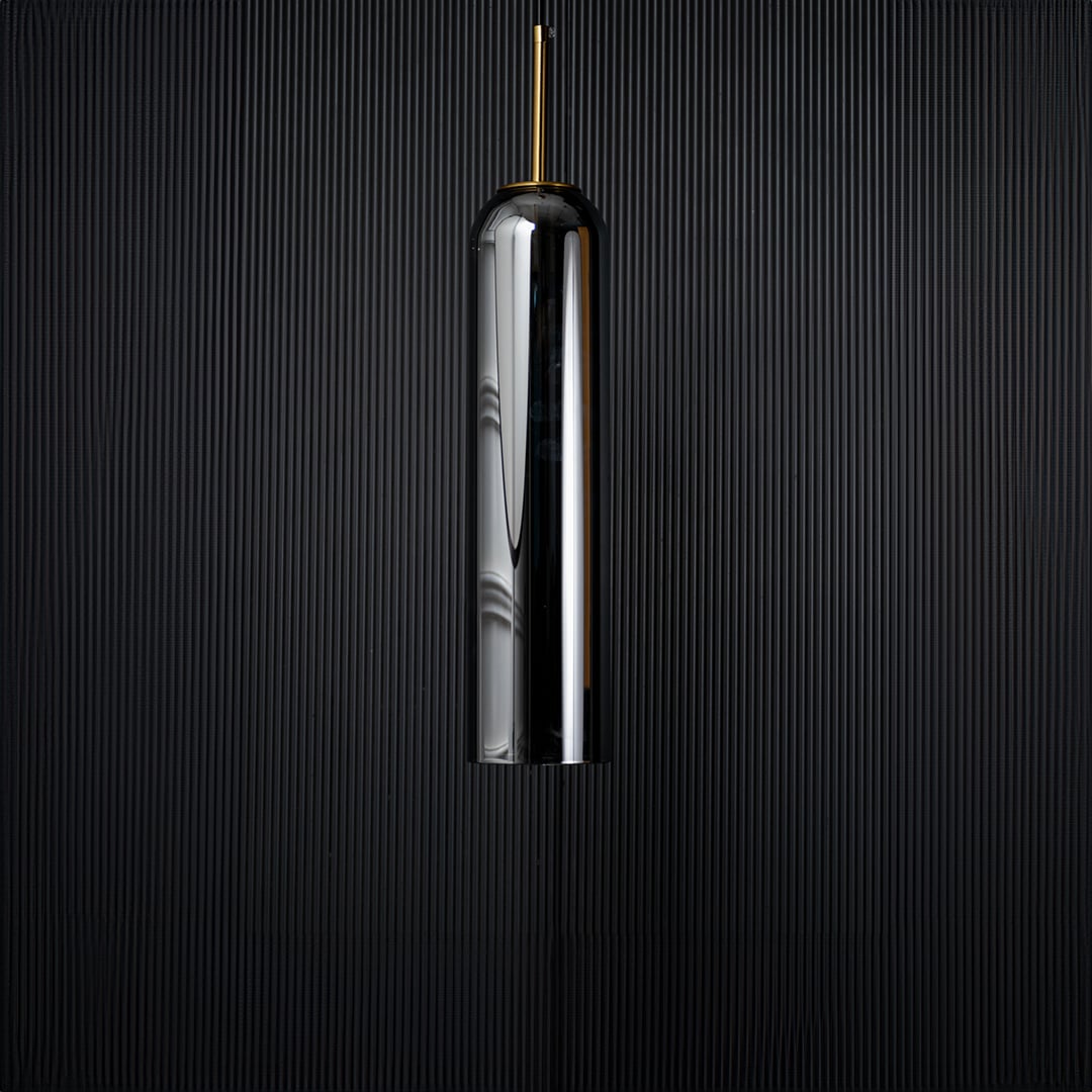 A tall silver cylindrical pendant light displayed on a black background with the light turned off emphasizing its glossy surface and slim elegant silhouette.