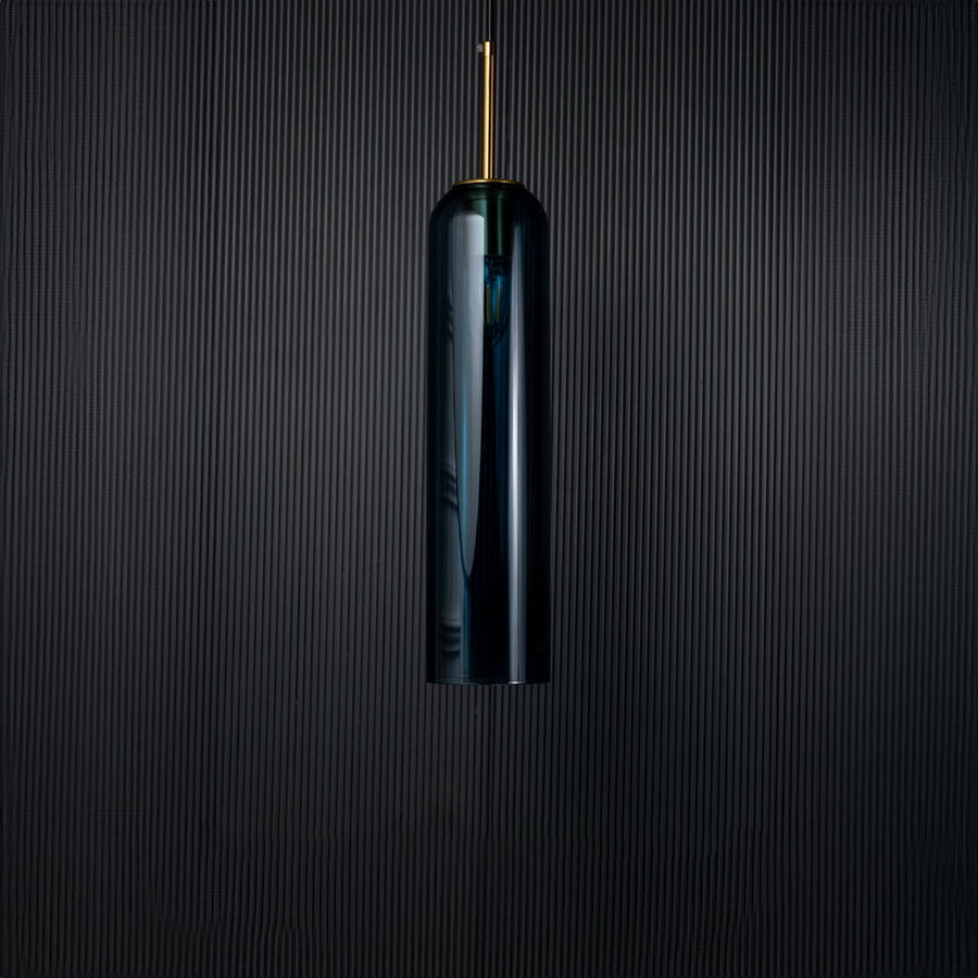 A blue glass pendant light turned off on a solid black background presenting its smooth cylindrical shape and rich blue tone with subtle gold features.