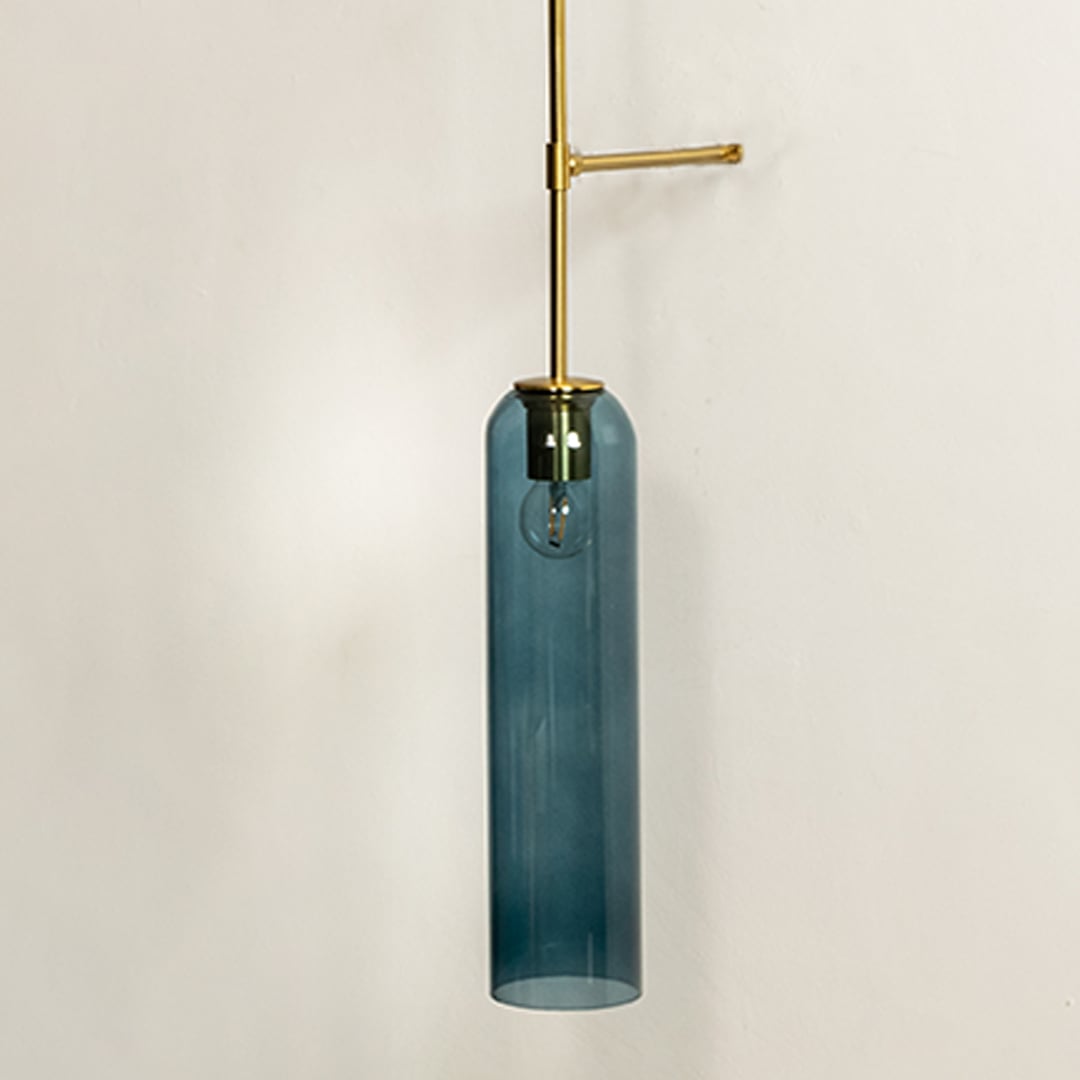 Closeup showing smooth blue glass cylinder shade and slender metal support arm highlighting refined craftsmanship suited for modern upscale interior home decor lighting.